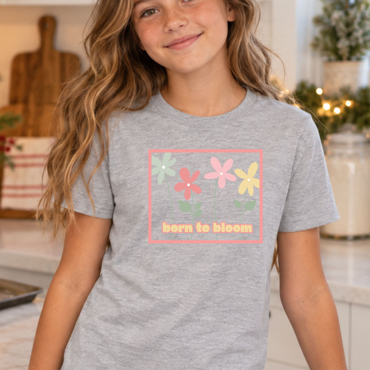 Youth model wearing an Athletic Heather Born to Bloom short sleeve tee, front view showing the colorful retro flower design.