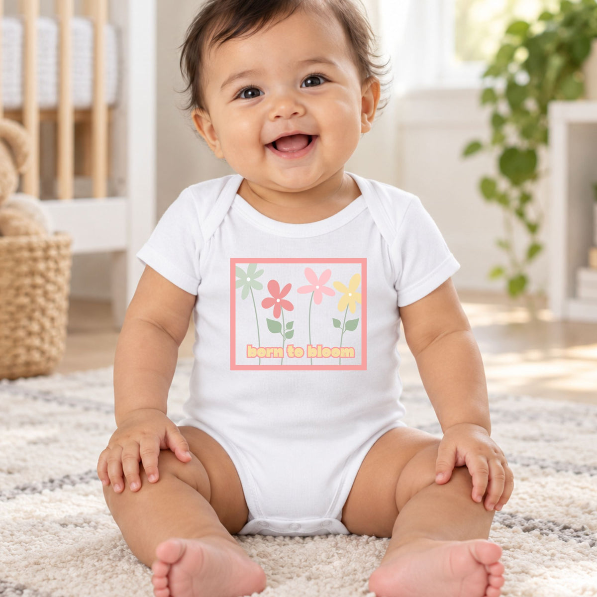 Baby wearing a white Born to Bloom infant bodysuit with a colorful retro flower design.