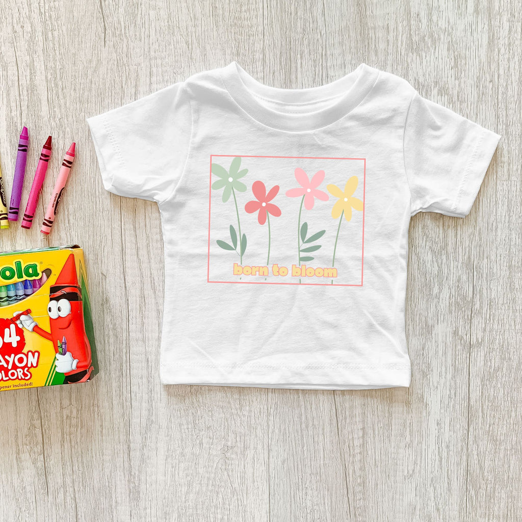 White toddler tee with the colorful Born to Bloom retro flower graphic.