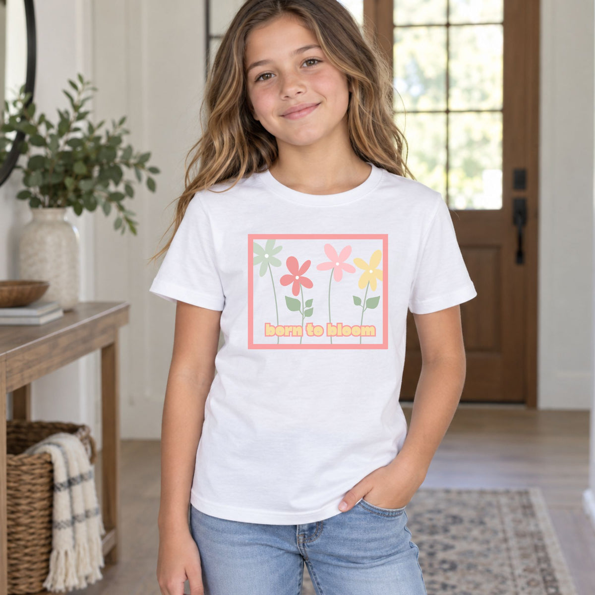 Youth model wearing a white Born to Bloom short sleeve tee, front view showing the colorful retro flower design.