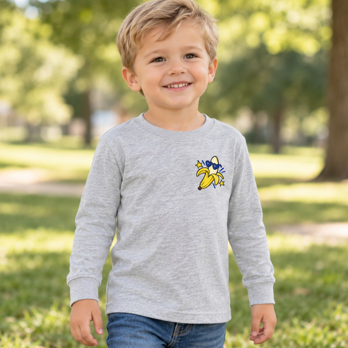 Toddler wearing a heather Go Bananas long sleeve tee, front view showing the banana left-chest design.