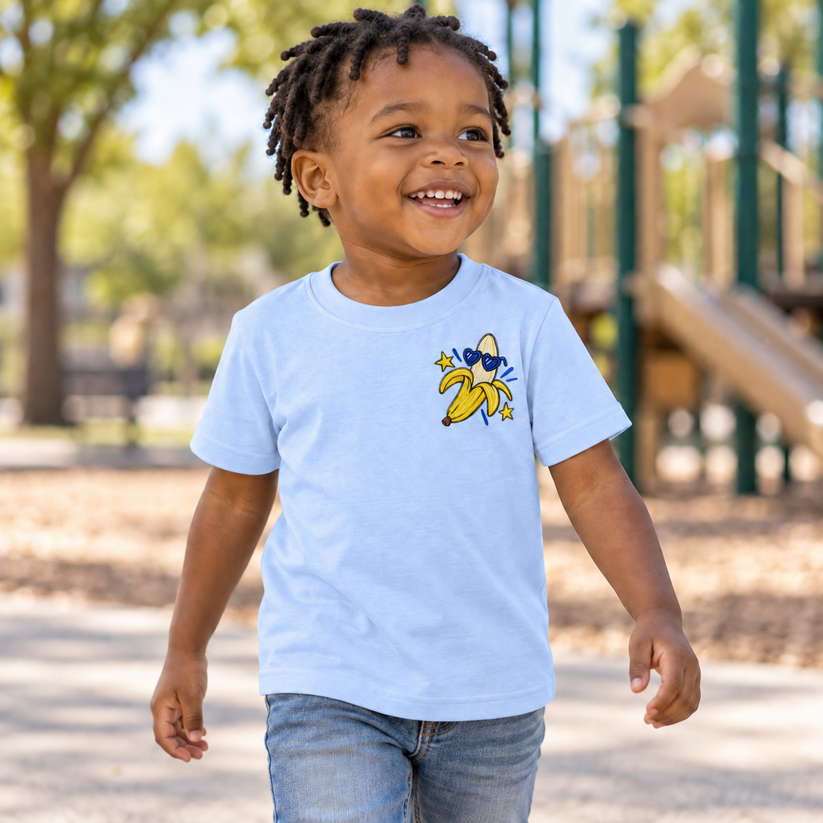 Toddler wearing a light blue Go Bananas short sleeve tee, front view showing the banana left-chest design.