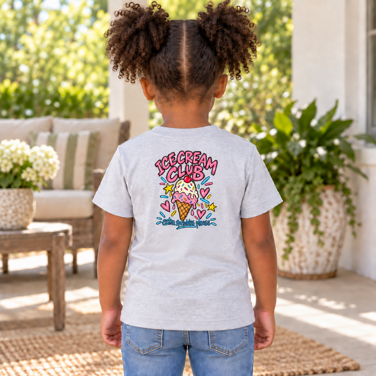 Toddler wearing a white Ice Cream Club short sleeve tee, back view showing the full ice cream cone design with “Extra Sprinkles Please.”