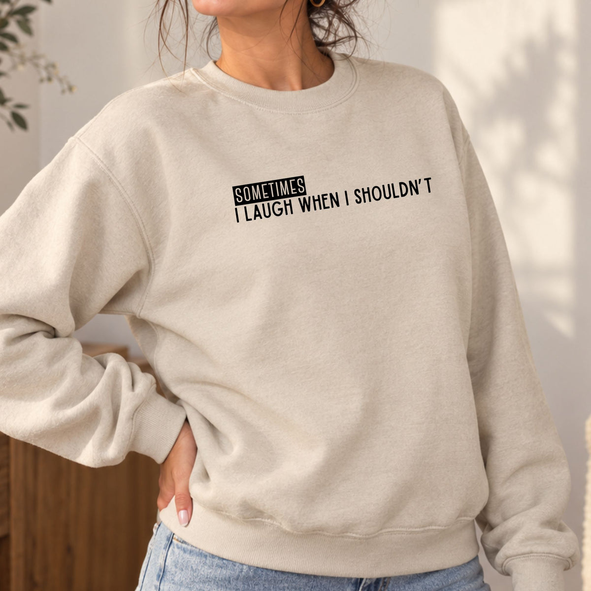 Woman wearing a sand Sometimes I Laugh When I Shouldn’t adult crewneck sweatshirt
